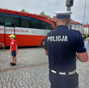 policjant idzie do autobusu z napisem mobilny punkt krwiodawstwa