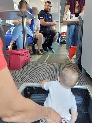 osoby i policjant we wnętrzu autobusu do pobierania krwi po schodkach wchodzi dziecko