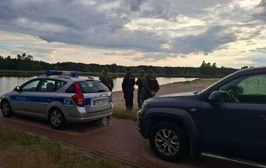 policjanci z strażą rybacką nad zbiornikiem wodnym