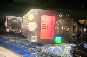 policyjny miernik prędkości z wyświetloną wartością 107 km/h leży na desce rozdzielczej samochodu