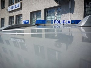 policyjna belka radiowozu na dachu radiowozu zaparkowanym przy budynku policji