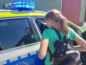 dziewczynka stoi przy policyjnym radiowozie
