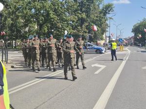 wojskowi podczas przemarszu przez jezdnię policjanci obserwujący przejście