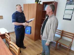 policjant wręcza mężczyźnie podziękowanie