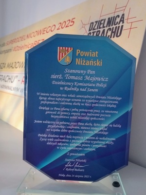 niebieska szklana statuetka z napisem powiat niżański szanowny pan sierżant tomasz majowicz dzielnicowy komisariatu policji w rudniku nad sanem