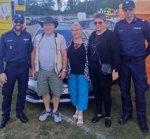 policjanci z osobami przy radiowozie służbowym podczas dożynek gminnych