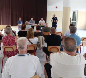 policjant podczas spotkania ze społeczeństwem w sali