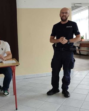 policjant wygłasza prelekcję w sali