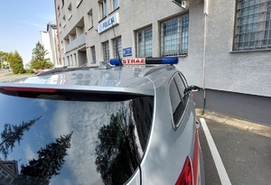radiowóz straży pożarnej pod budynkiem komendy policji widok od strony dachu radiowozu
