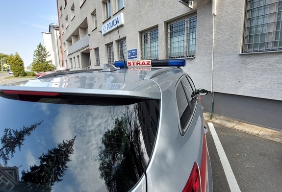 radiowóz straży pożarnej pod budynkiem komendy policji widok od strony dachu radiowozu