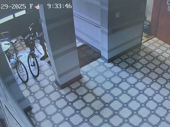 widok z kamery monitoringu korytarzu na którym w rogu stoją dwa rowery a przy jednym z nich jest widoczna sylwetka człowieka, fotografowano : KPP NISKO
