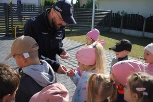Policjant rozmawia z dziećmi.