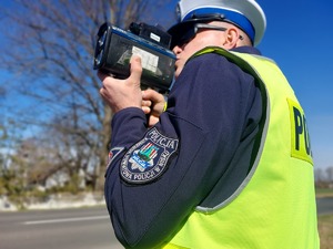 Policjant mierzy prędkość pojazdów.