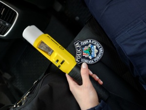Urządzenie do badania stanu trzeźwości w ręce policjanta na tle kurtki z widocznym emblematem KPP Nisko.
