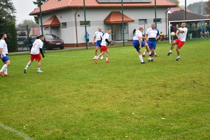Na boisku piłkarze dwóch drużyn grają w piłę nożną.
