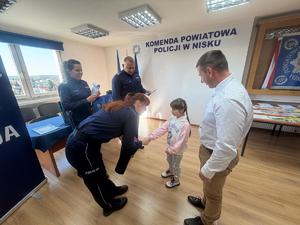 Laureatka konkursu Bezpieczne Wakacje 2025 odbiera nagrodę od policjantów Komendy Powiatowej Policji w Nisku.