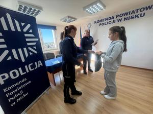 Laureatka konkursu Bezpieczne Wakacje 2025 odbiera nagrodę od policjantów Komendy Powiatowej Policji w Nisku.