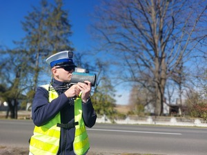 Policjant Ruchu Drogowego mierzy prędkość za pomocą urządzenia pomiarowego