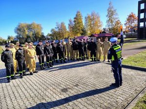 Policjant stoi i pokazuje gesty używane do kierowania ruchem drogowym.