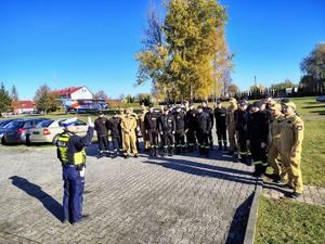 Policjant stoi i pokazuje gesty używane do kierowania ruchem drogowym.