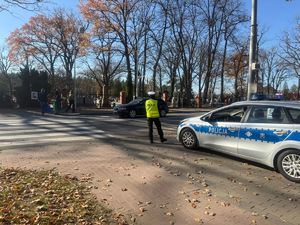 Policjantka nadzoruje ruch w rejonie przejśćia dla pieszych przy cmentarzu