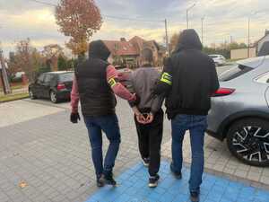 Policjanci prowadzą zatrzymanego