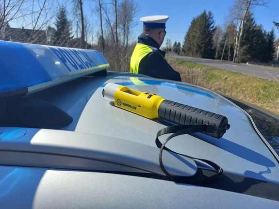 Urządzenie do badania stanu trzeźwości na dachu radiowozu, w tle policjant
