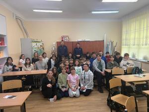 dzieci kucają na podłodze za nimi stoją policjanci na tle mebli