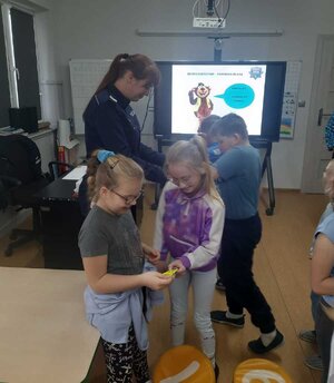 Policjantka rozdaje odblaski