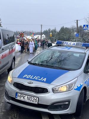 radiowóz policyjny, za nim orszak trzech króli